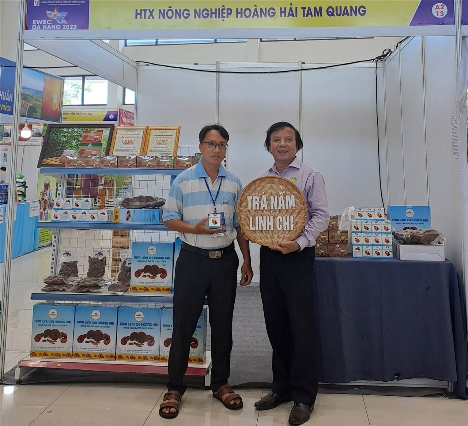 Giám đốc HTX Nông nghiệp Hoàng Hải Tam Quang -Nguyễn Thanh Vũ (bên trái) cùng gian hàng với các sản phẩm OCOP của HTX.