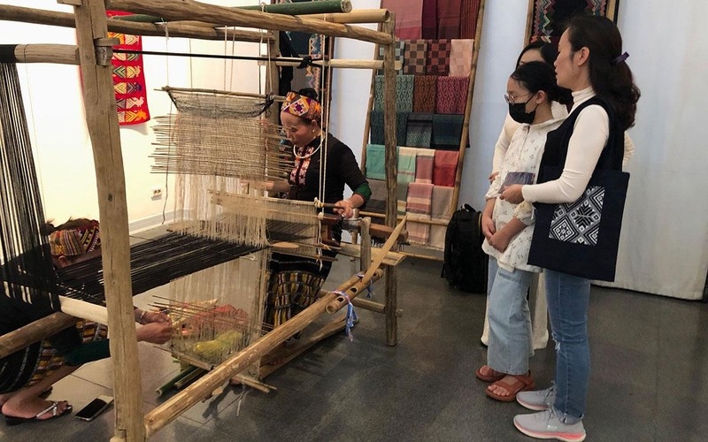 Khách tham quan triển lãm thích thú với phần trình diễn nghề dệt của nghệ nhân dân tộc Thái (nhóm Thái Thanh)