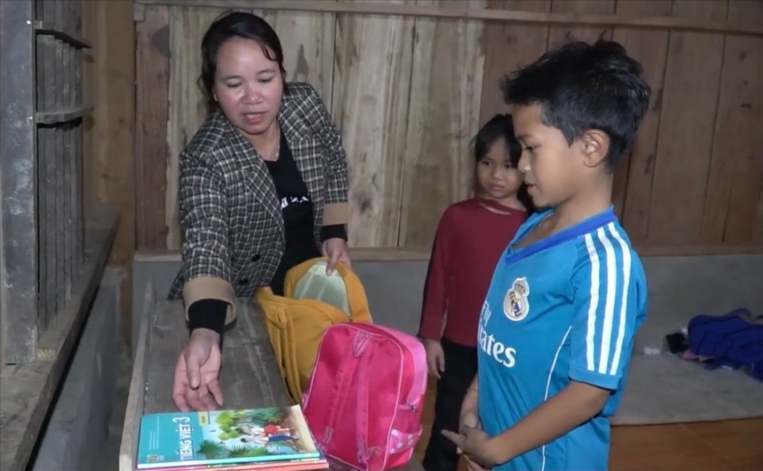 Chị Hồ Thị Quý kiểm tra sách vở, áo quần cho hai con đến trường