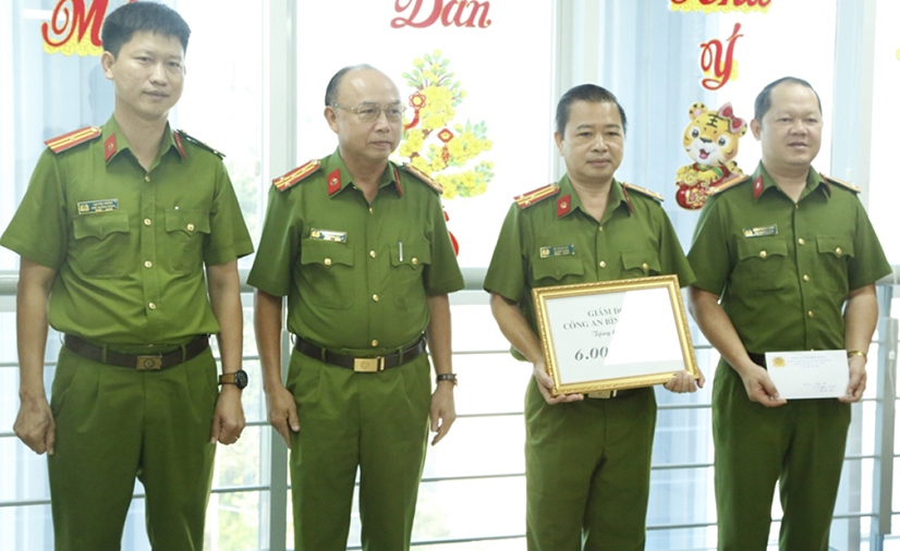 Đại tá Trần Văn Chính - Phó Giám đốc, Thủ trưởng Cơ quan Cảnh sát điều tra Công an tỉnh Bình Dương (thứ 2 từ trái qua) trao thưởng cho 2 đơn vị có thành tích xuất sắc