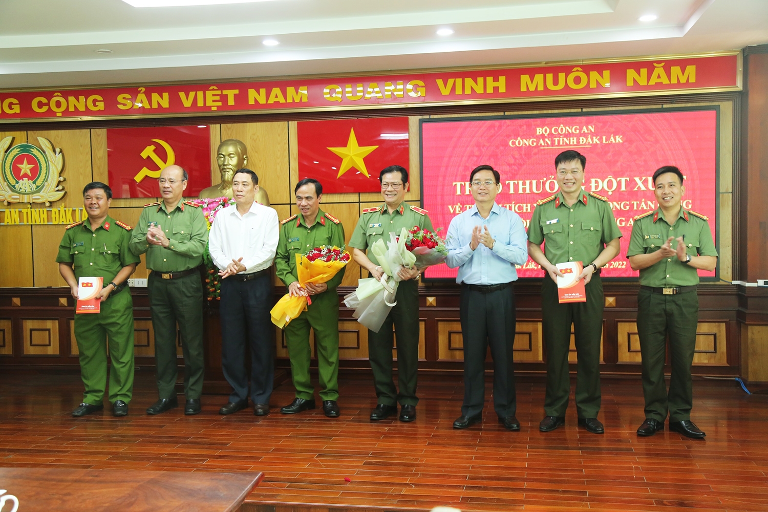 Bí thư Tỉnh ủy Đắk Lắk Nguyễn Đình Trung (thứ 3 từ phải qua) và Phó Chủ tịch UBND tỉnh Võ Văn Cảnh (thứ 3 từ trái qua) tặng hoa lãnh đạo Công an tỉnh và 2 phòng nghiệp vụ phá án