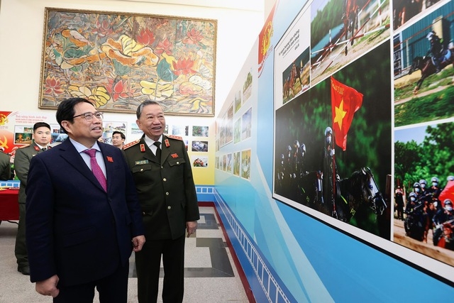 Thủ tướng Phạm Minh Chính và Đại tướng Tô Lâm, Bộ trưởng Bộ Công an xem trưng bày ảnh về các hoạt động của lực lượng công an - Ảnh: VGP/Nhật Bắc