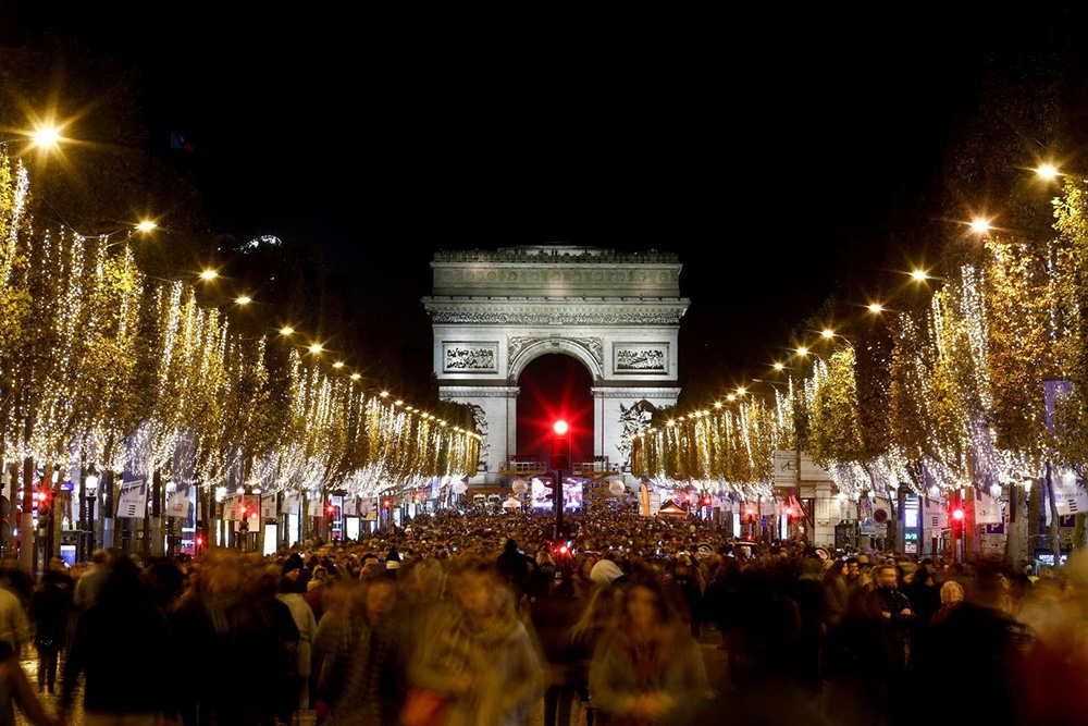 Người dân Paris và du khách tham gia lễ thắp sáng đèn dịp Giáng sinh ở đại lộ Champs-Elysees và Khải Hoàn Môn, Pháp