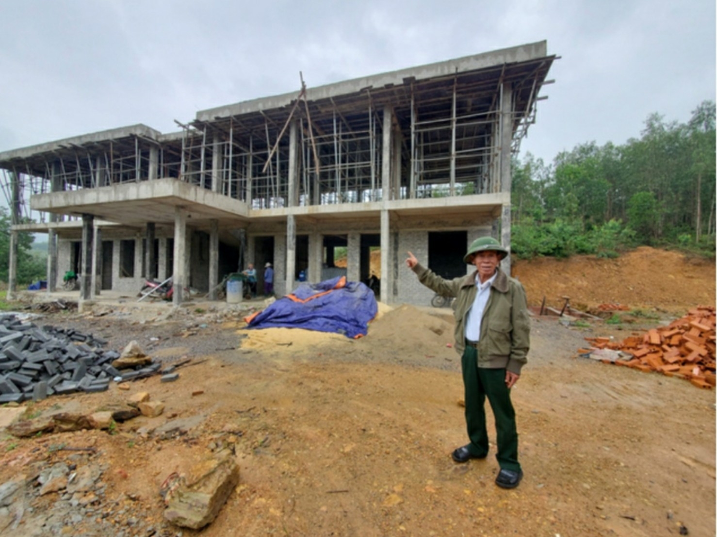 Ông Hồ Văn Hơn bên ngôi trường mới được xây dựng trên phần đất ông hiến tặng