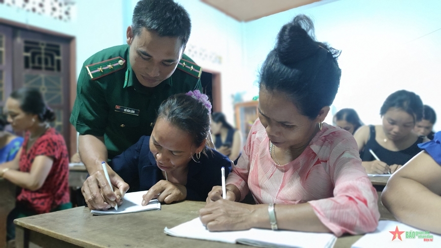 Trung úy Hồ Văn Lăng hướng dẫn học viên lớp học chống tái mù chữ ở thôn A Ho 
