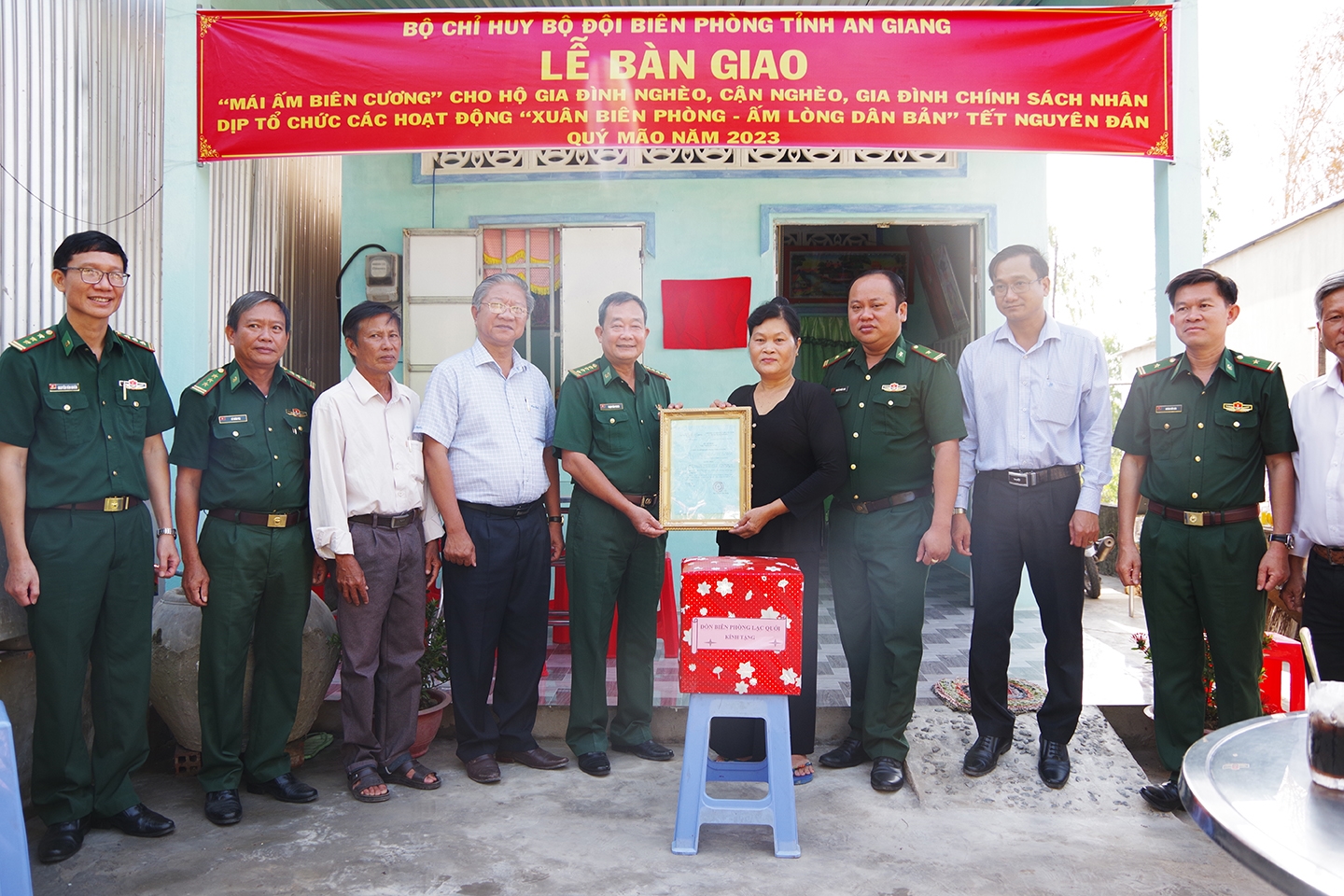 Đại tá Phạm Văn Phong (thứ 5 từ trái qua) - Chính ủy Bộ đội Biên phòng An Giang trao quyết định tặng nhà đến hộ khó khăn 