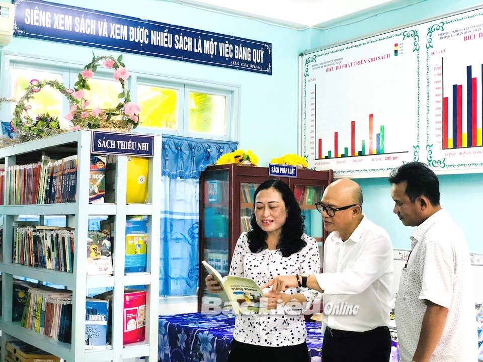 Bà Trần Thị Hoa Ry - Phó Chủ tịch Hội đồng Dân tộc của Quốc hội xem sách dạy chữ Khmer tại Trường tiểu học Trần Quốc Toản (xã Hưng Hội, huyện Vĩnh Lợi)