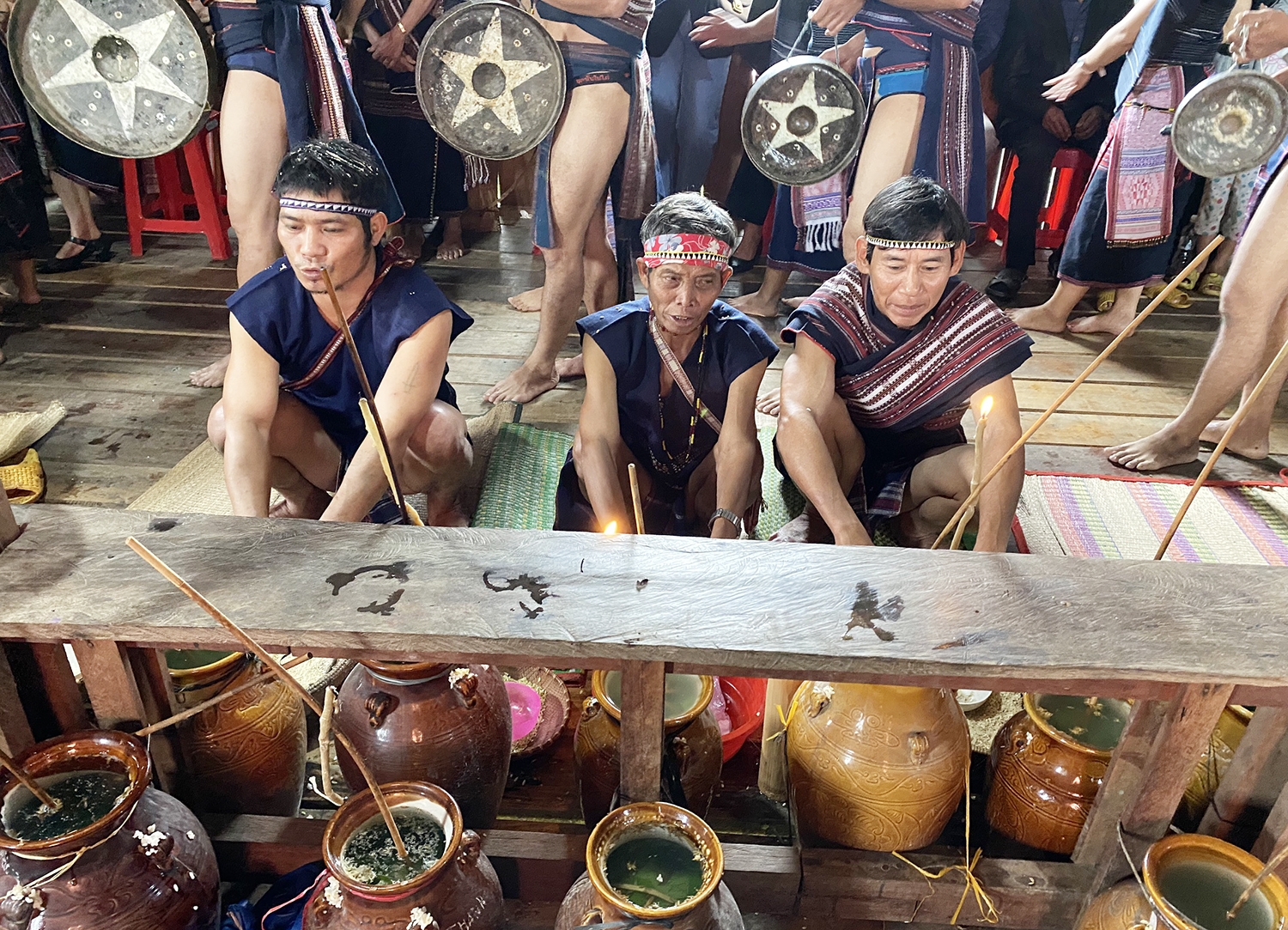 Già làng Đinh Văn Hiếp (ngồi giữa) thực hiện nghi lễ cúng lúa mới