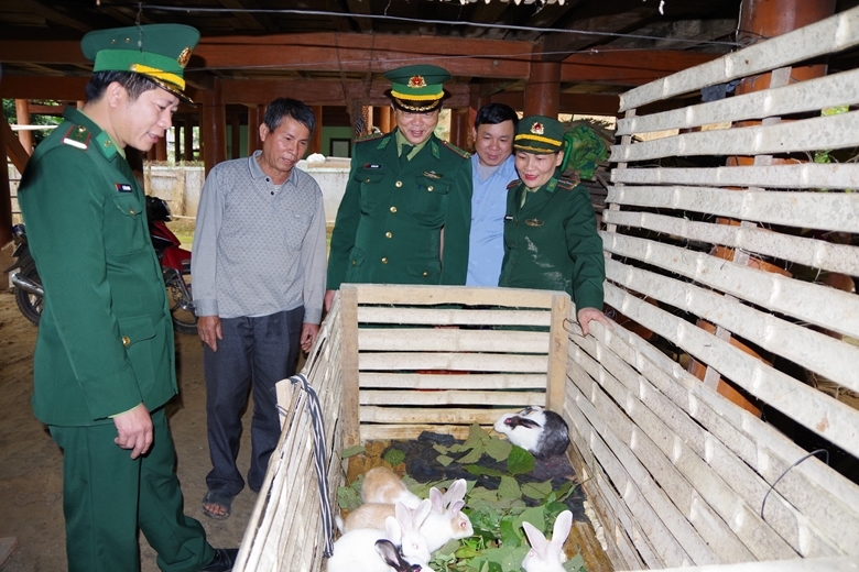 Thiếu tá Lê Văn Giang (ngoài cùng bên trái) cùng cán bộ đồn Thông Thụ và địa phương kiểm tra mô hình chăn nuôi thỏ tại gia đình ông Lương Văn Hồng