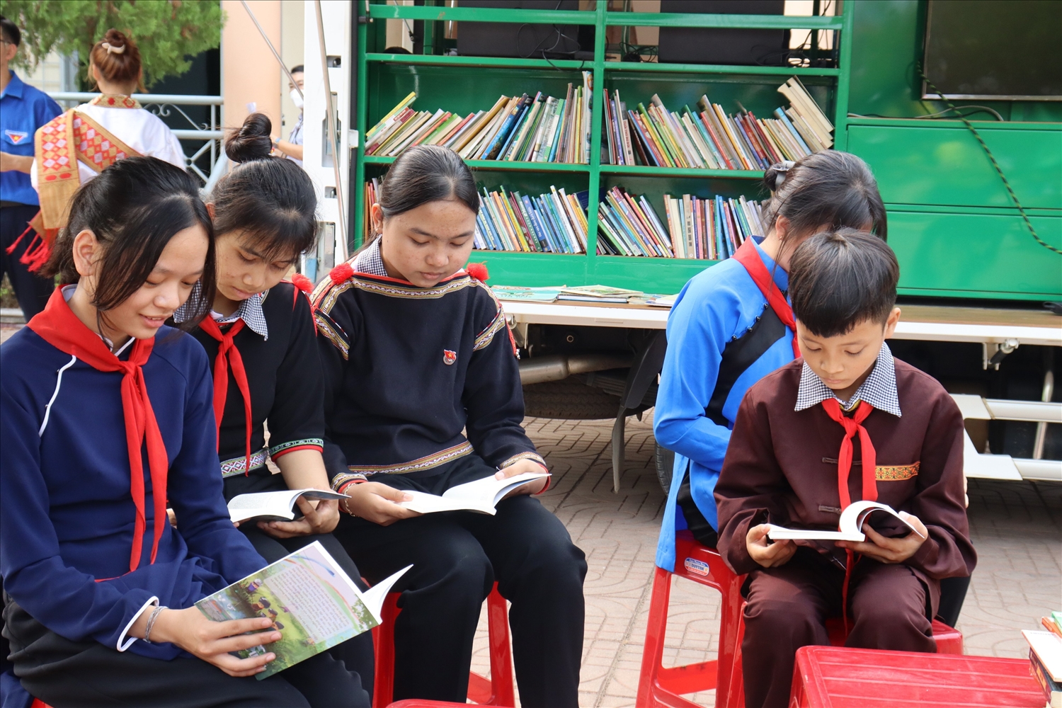 Các em học sinh đọc sách tại xe thư viên lưu động