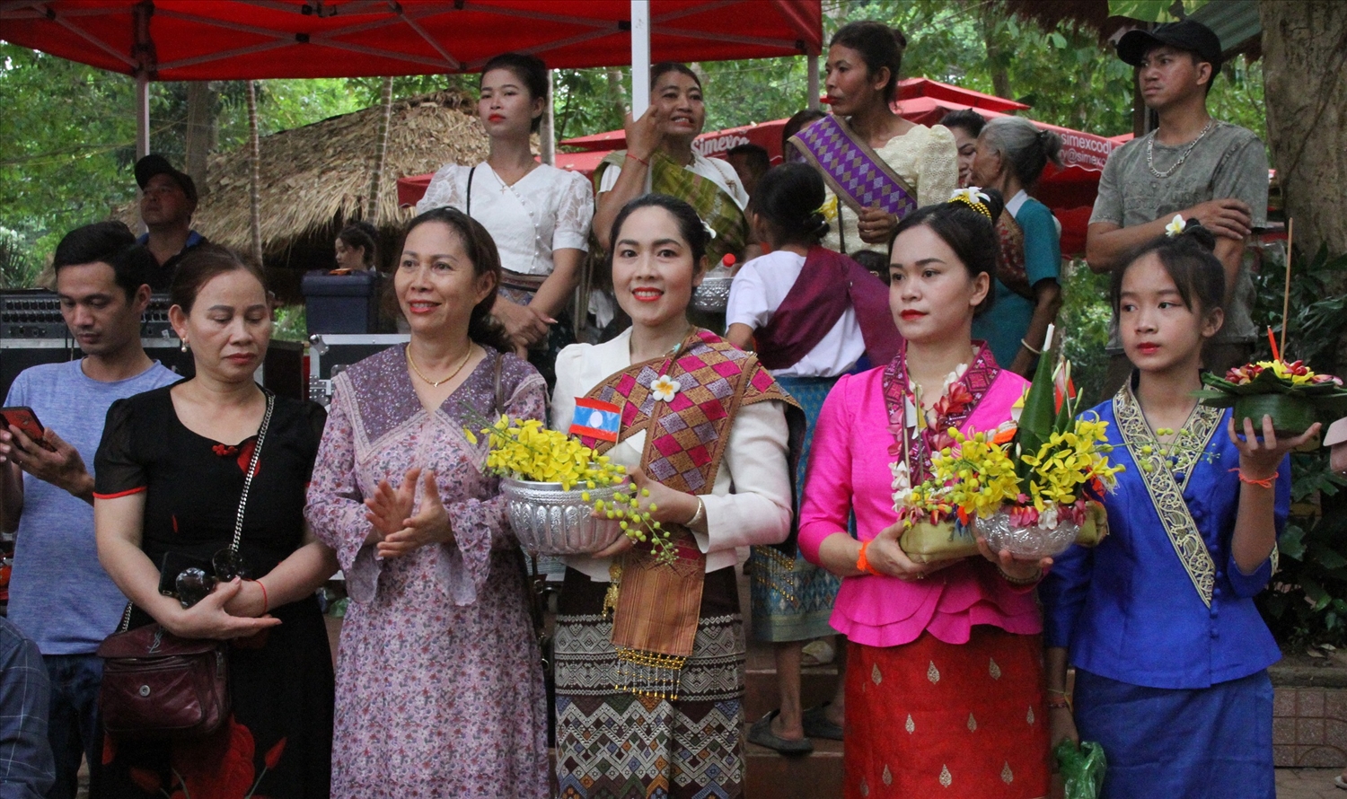 Các cô gái Lào mang trang phục truyền thống cài bông hoa chăm pa trên đầu đi dự hội