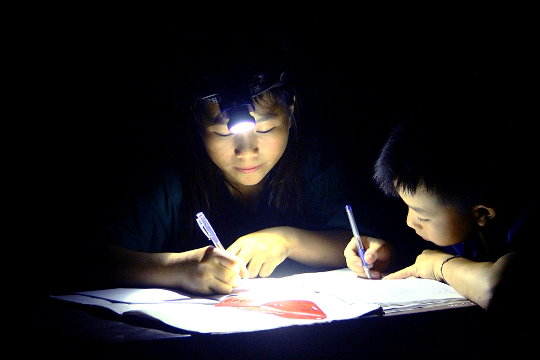 Trẻ em ở bản Phà Chiếng xã Mỹ Lý (Kỳ Sơn) học bài nhờ ánh đèn pin trên đầu
