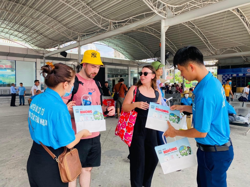 Cán bộ huyện Cô Tô tuyên truyền và cung cấp túi giấy thay thế túi nilon cho du khách