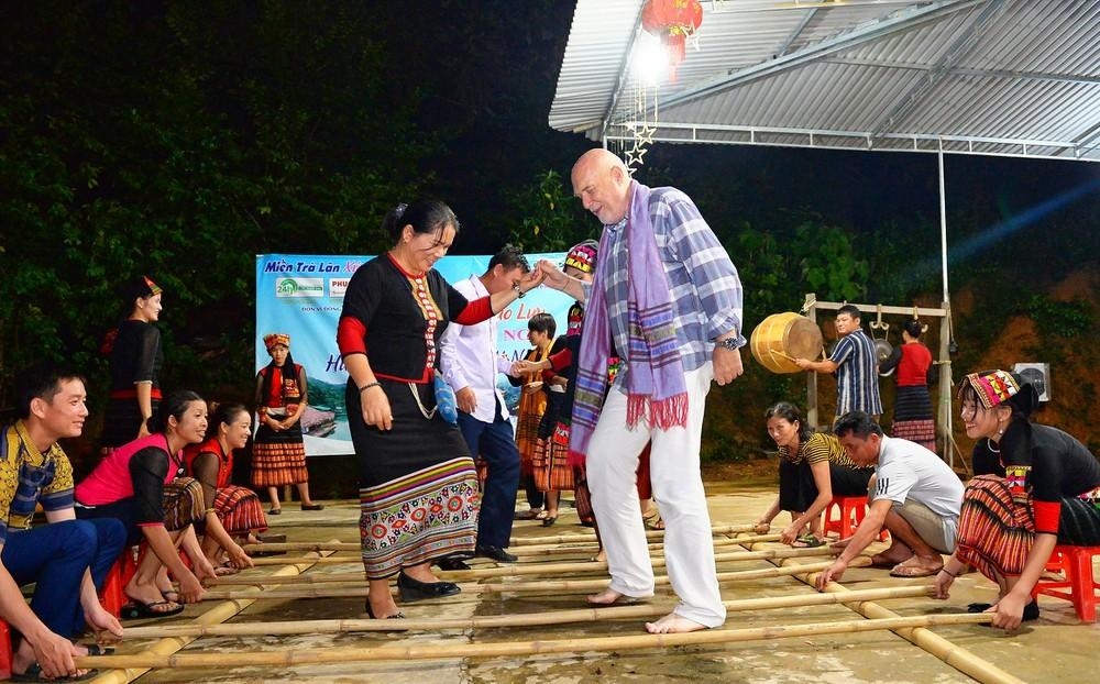 Du khách nước ngoài say sưa với điệu nhảy sạp tại điểm du lịch cộng đồng bản Khe Rạn, xã Bồng Khê, huyện Con Cuông