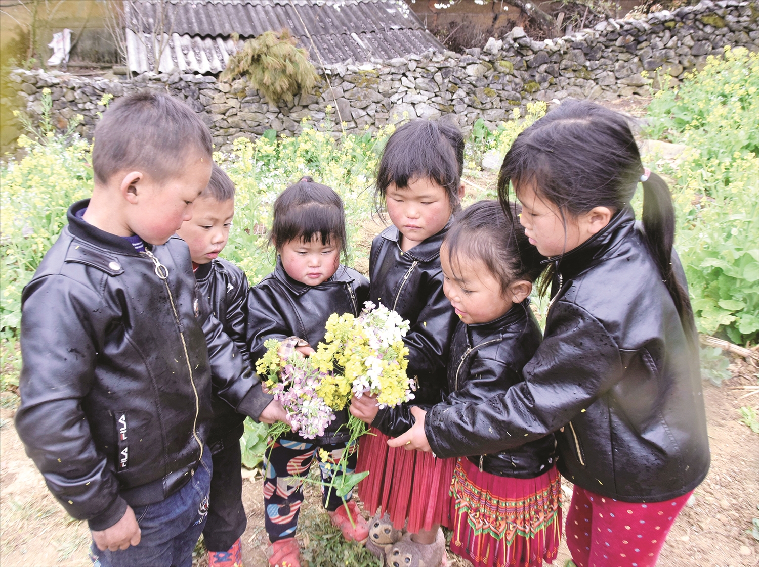 Trẻ em vùng cao cùng với bó hoa cải tươi thắm