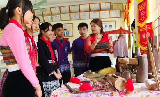 Các em học sinh trường Phổ thông Dân tộc Nội trú THCS và THPT Mai Châu B nghe cô giáo giới thiệu về nhạc cụ truyền thống của các dân tộc tại Phòng truyền thống của Nhà trường