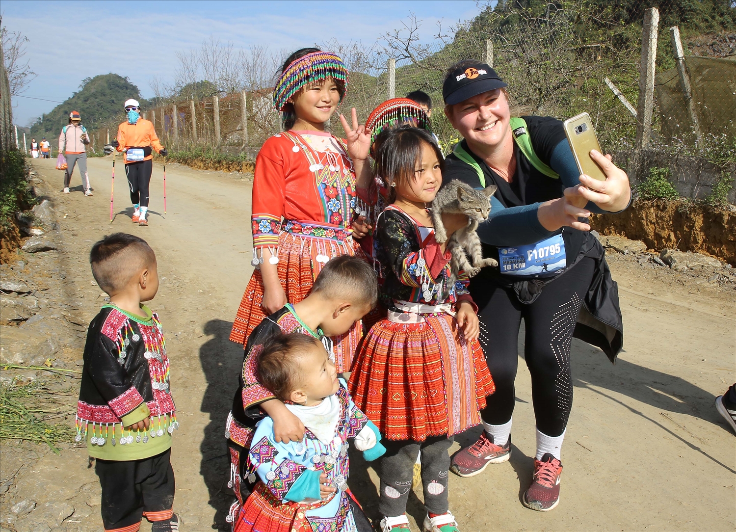Vận động viên người nước ngoài vô cùng thích thú chụp ảnh cùng các em nhỏ người Mông trên đường chạy