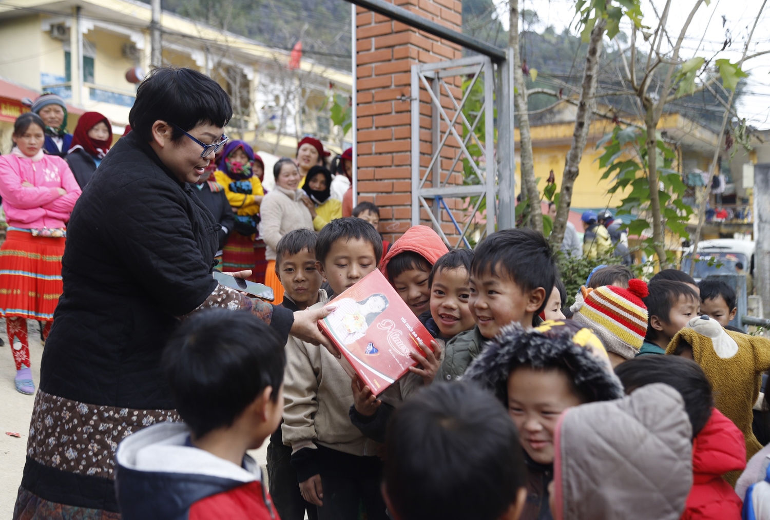 Bà Nguyễn Thùy Như - Phó Trưởng ban Chuyên đề Báo Dân tộc và Phát triển trao túi sưởi giữ nhiệt cho các cháu học sinh Trường Tiểu học Lũng Thầu