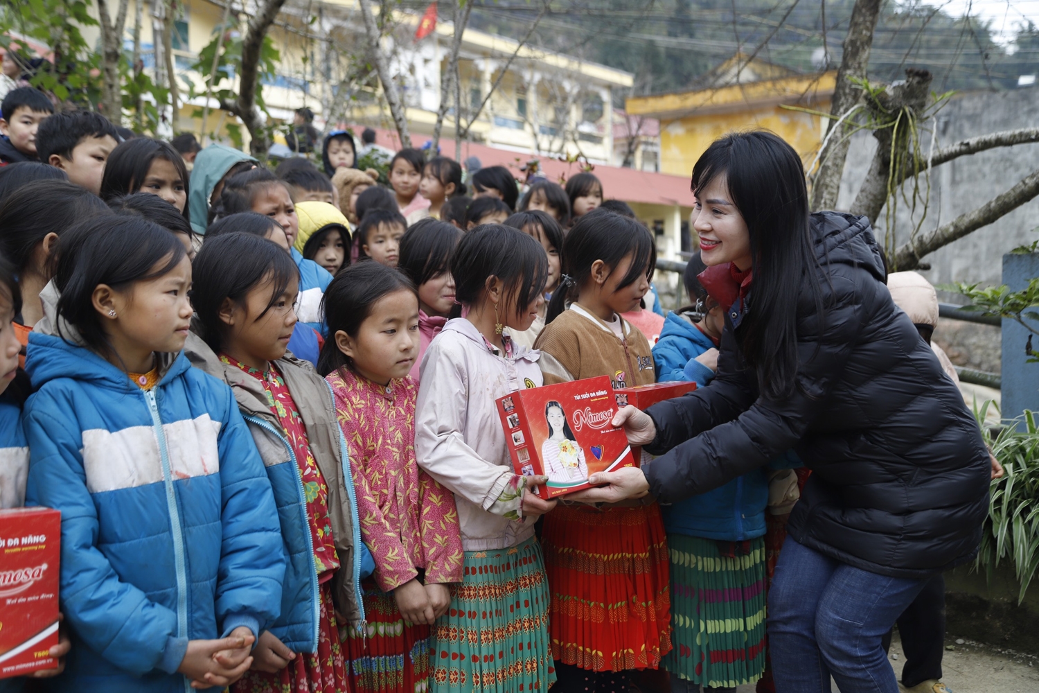 Phó Tổng Biên tập Hoàng Thị Thanh trao túi sưởi giữ nhiệt cho các cháu học sinh Trường Tiểu học Lũng Thầu