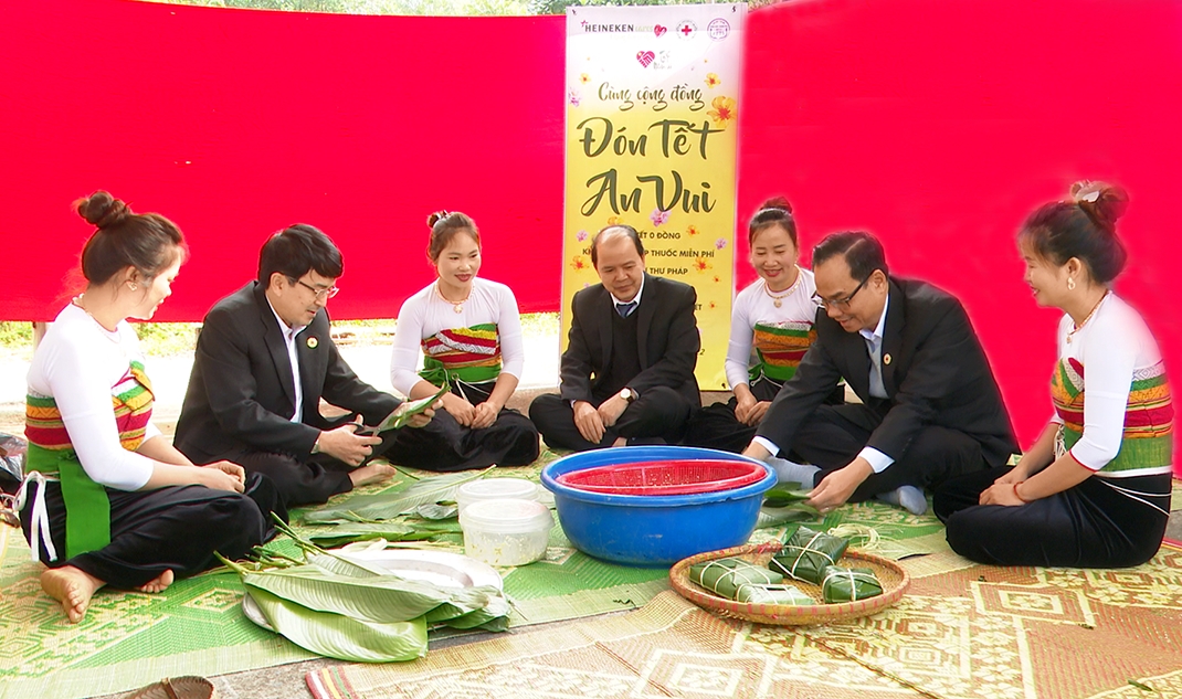 Người dân và Ban Tổ chức chương trình "Tết nhân ái" cùng gói bánh chưng tại xã Thành Lâm (huyện Bá Thước)