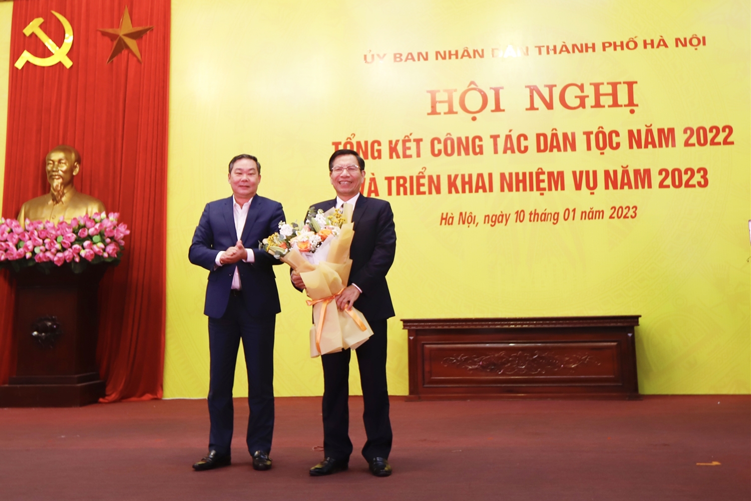 Phó Chủ tịch Thường trực UBND Thành phố Lê Hồng Sơn tặng hoa cho nguyên Trưởng ban Dân tộc TP. Hà Nội Nguyễn Tất Vinh