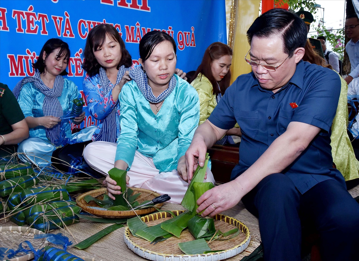 Chủ tịch Quốc hội Vương Đình Huệ tham gia gói bánh Tét tại chợ Tết công đoàn 2023. 
