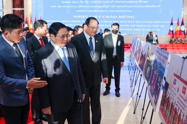 Thủ tướng Phạm Minh Chính cùng Thủ tướng Lào Sonexay Siphandone tham quan trưng bày ảnh giới thiệu đất nước, con người và quan hệ gắn bó, tin cậy, thủy chung, trong sáng, hợp tác toàn diện Việt Nam-Lào - Ảnh: VGP/Nhật Bắc