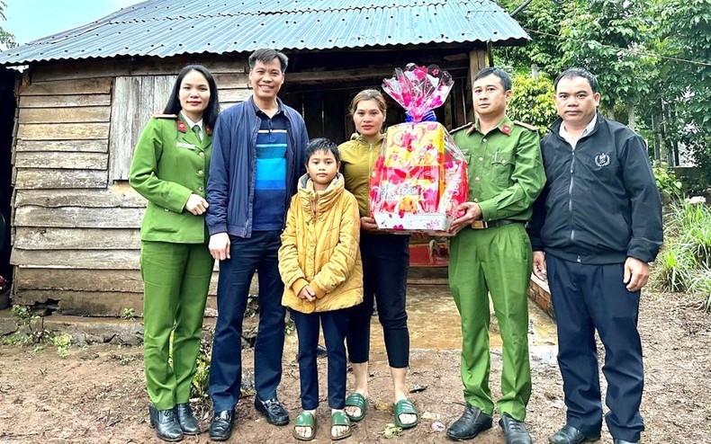 Ðại diện Công an thị xã Buôn Hồ (tỉnh Ðắk Lắk) trao quà Tết tặng các hộ có hoàn cảnh khó khăn