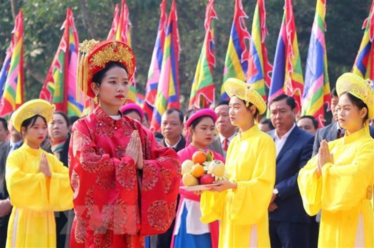 Chủ tế nữ mặc bộ lễ phục mầu đỏ thực hiện nghi thức tế lễ truyền thống. (Ảnh: TTXVN)