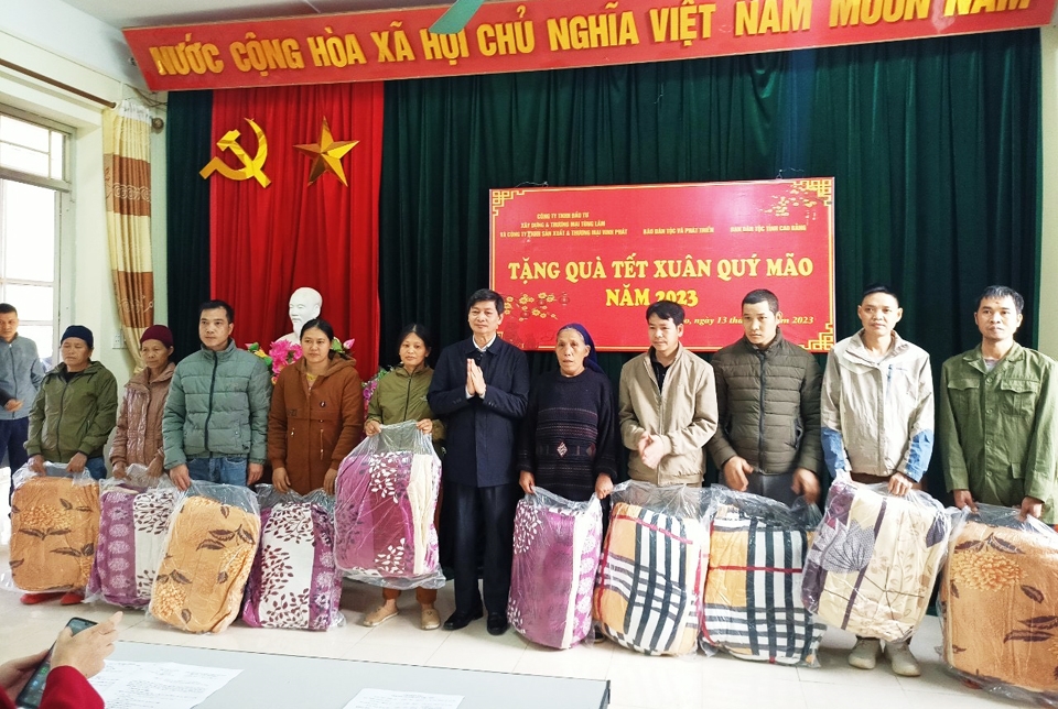 Ông Bế Văn Hùng (người đứng giữa) trao tặng quà cho các hộ gia đình khó khăn tại xã Tự Do, huyện Quảng Hòa, tỉnh Cao Bằng