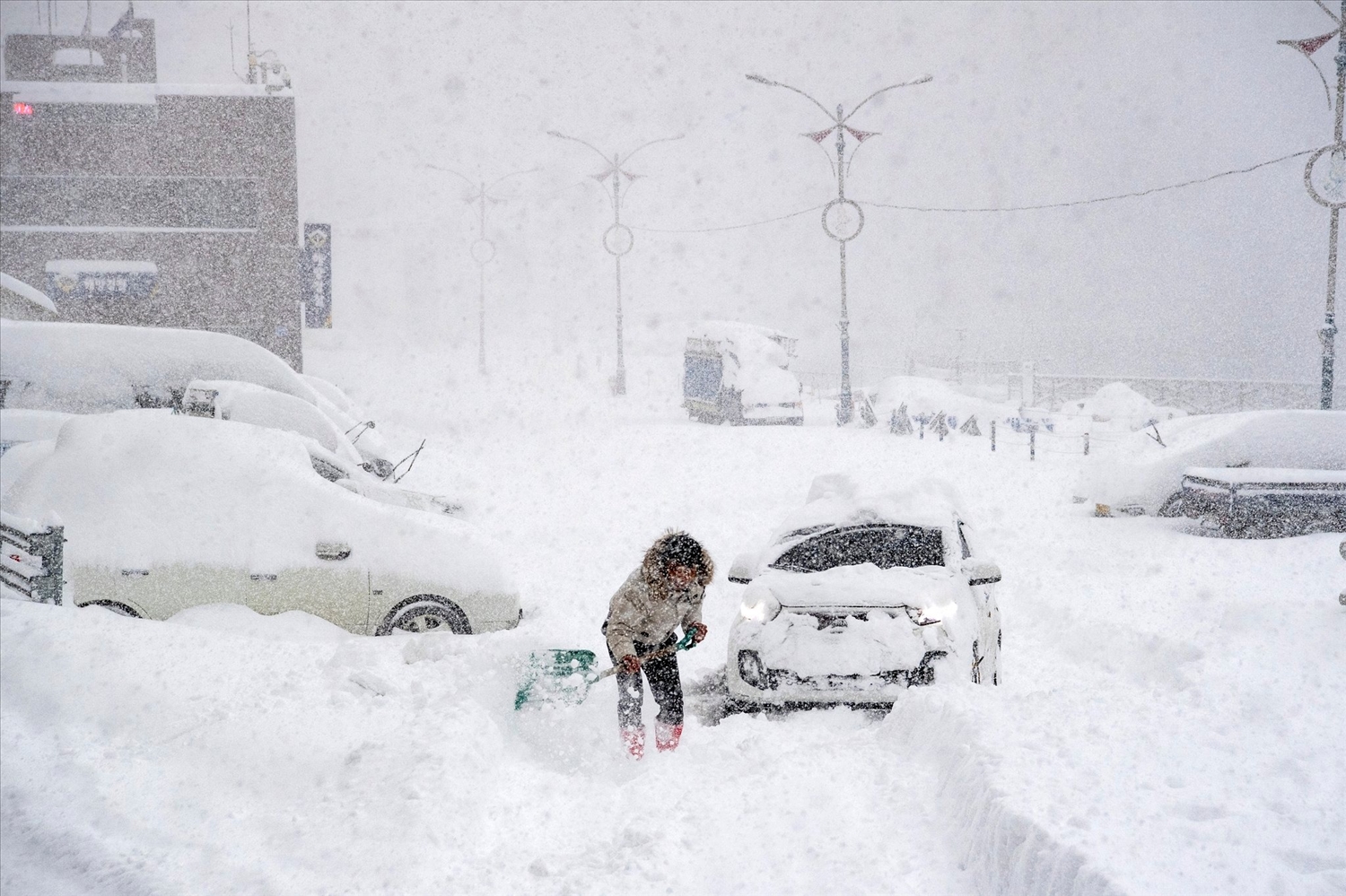 Một người dân xúc tuyết dọn đường cho ôtô trên đảo Ulleung, huyện Uljin, tỉnh Gangwon, Hàn Quốc. Ảnh: Yonhap.