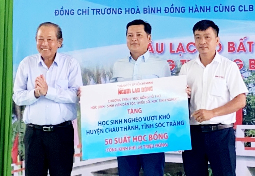 Nguyên Phó Thủ tướng Thường trực Trương Hòa Bình (bìa trái) trao bảng tượng trưng tặng 50 suất học bổng cho học sinh DTTS huyện Châu Thành