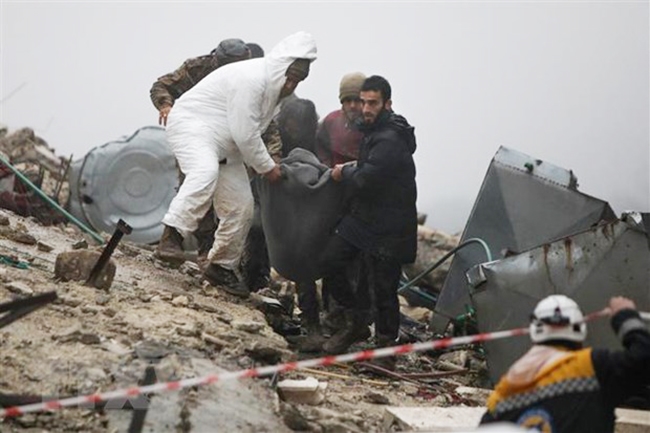  Lực lượng cứu hộ chuyển nạn nhân bị thương ra khỏi đống đổ nát sau trận động đất tại Afrin, tỉnh Aleppo (Syria). (Ảnh: AFP/TTXVN)