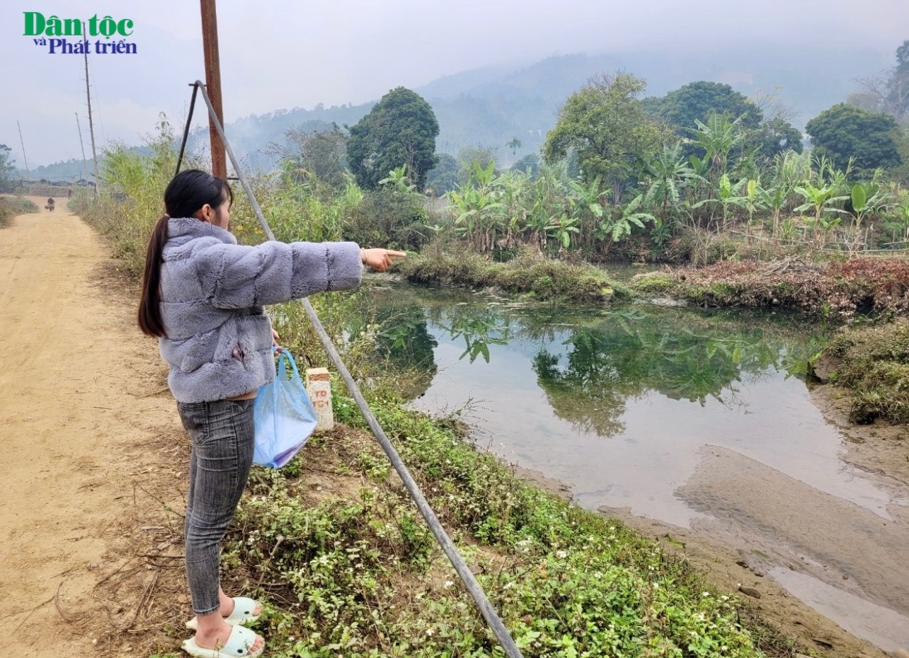 Chị Hà Thị Cường con ông Nông Văn Lự chỉ cho phóng viên về khu vực thửa đất của gia đình mình bị ngập nước nhưng không được bồi thường