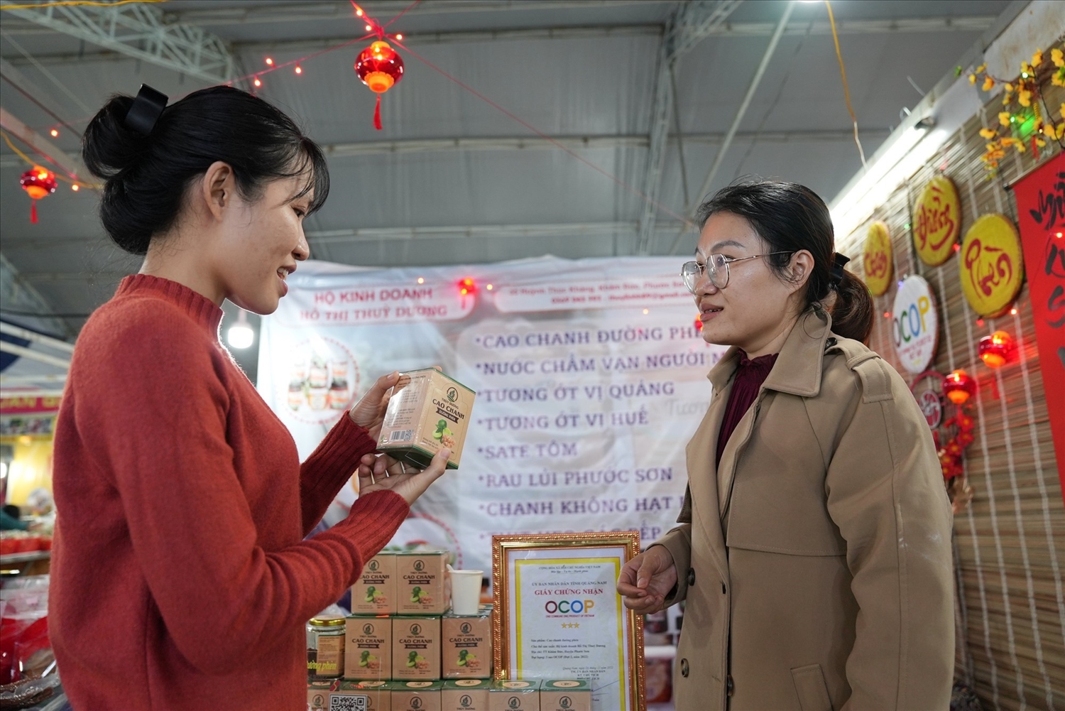 Chị Hồ Thị Thùy Linh (bên phải) giới thiệu sản phẩm cao chanh đường phèn mang tên Thùy Dương cho khách hàng. Ảnh: L.Q