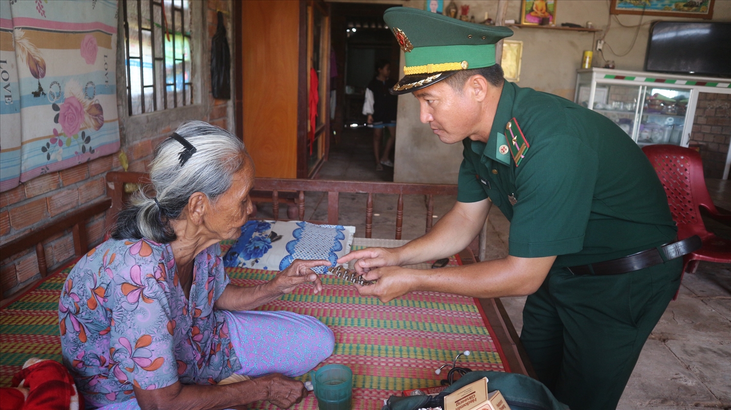Thiếu tá Lê Văn Quốc khám bệnh, cấp thuốc cho người già có hoàn cảnh khó khăn trên địa bàn khu vực biên giới biển xã Vĩnh Hải