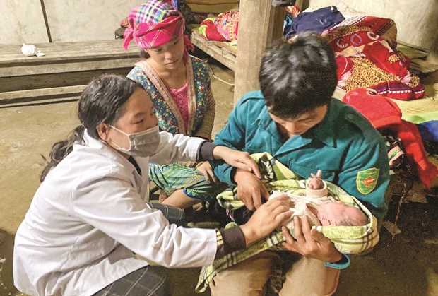 Cán bộ Trạm Y tế xã Dà Sề Phìn (huyện Sìn Hồ, Lai Châu) hướng dẫn vợ chồng trẻ chăm sóc trẻ sơ sinh. (Ảnh Việt Hoàng)