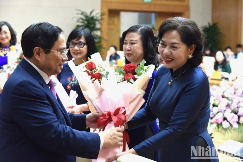Thủ tướng Phạm Minh Chính tặng hoa các nữ đại biểu tại buổi gặp mặt. (Ảnh: TRẦN HẢI)