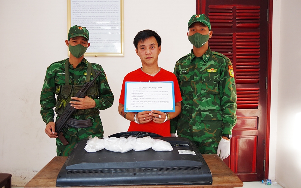Bị cáo cáo Huỳnh Công Nhựt Hóa (áo đỏ) cùng tang vật tại đồn Biên phòng Vĩnh Nguơn 