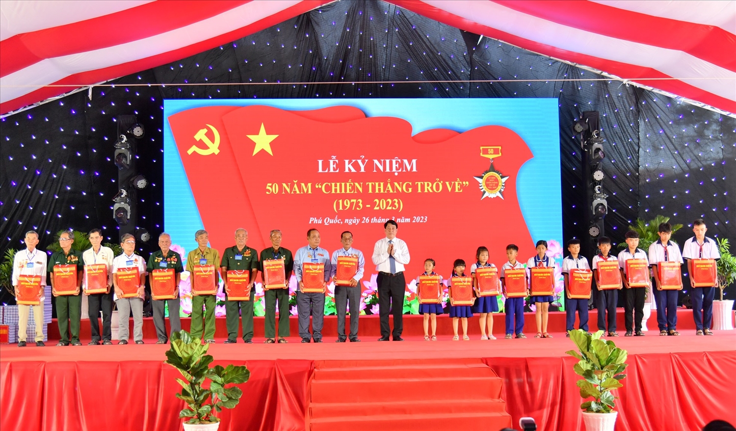 Đại tướng Lương Cường, Ủy viên Bộ Chính trị, Chủ nhiệm Tổng cục Chính trị Quân đội nhân dân Việt Nam trao quà đến đại biểu dự lễ và học sinh là con, em gia đình chính sách 
