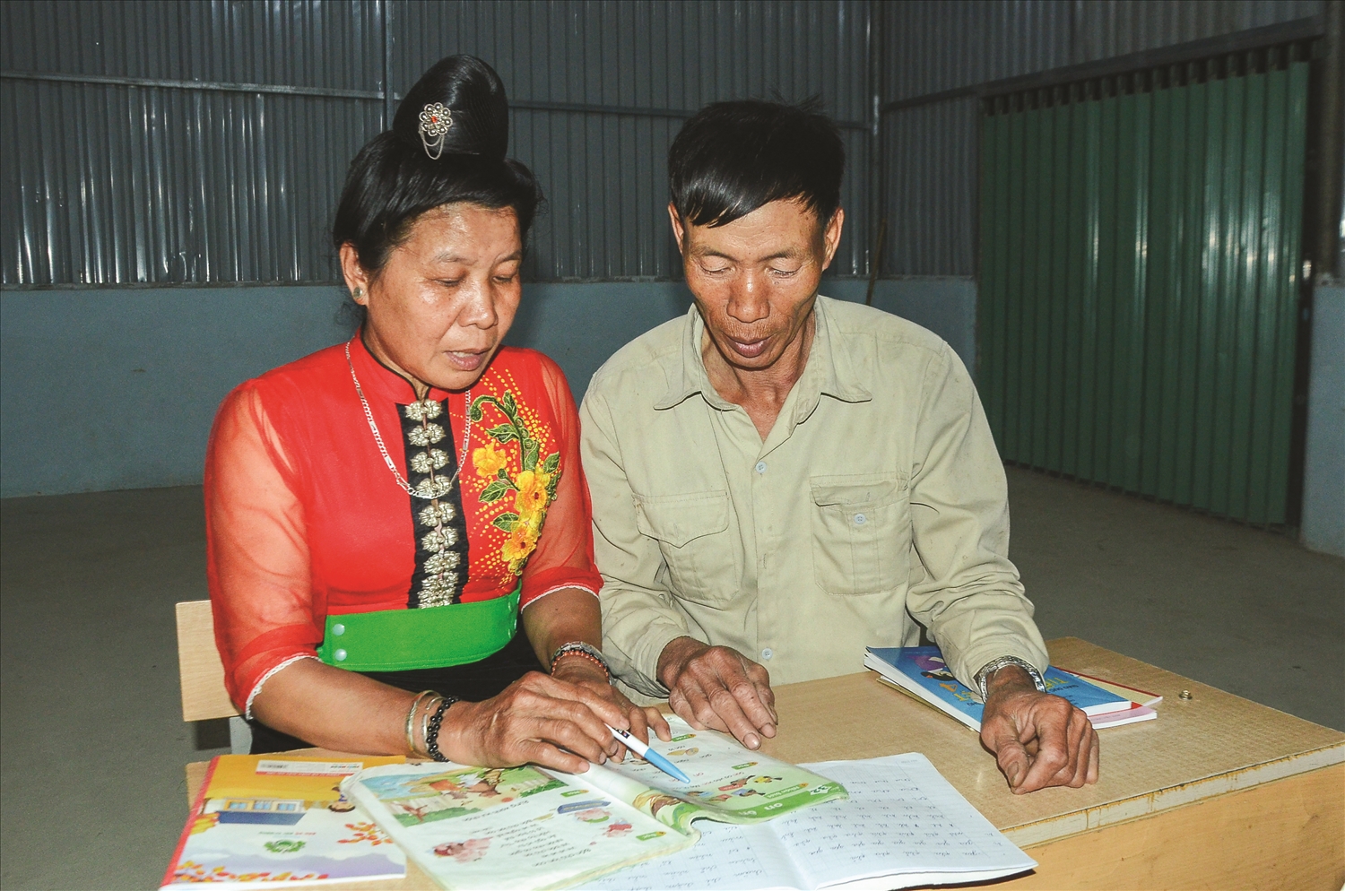 Vợ chồng bà Lò Thị Phượng và ông Tòng Văn Tiên hỗ trợ nhau học chữ.