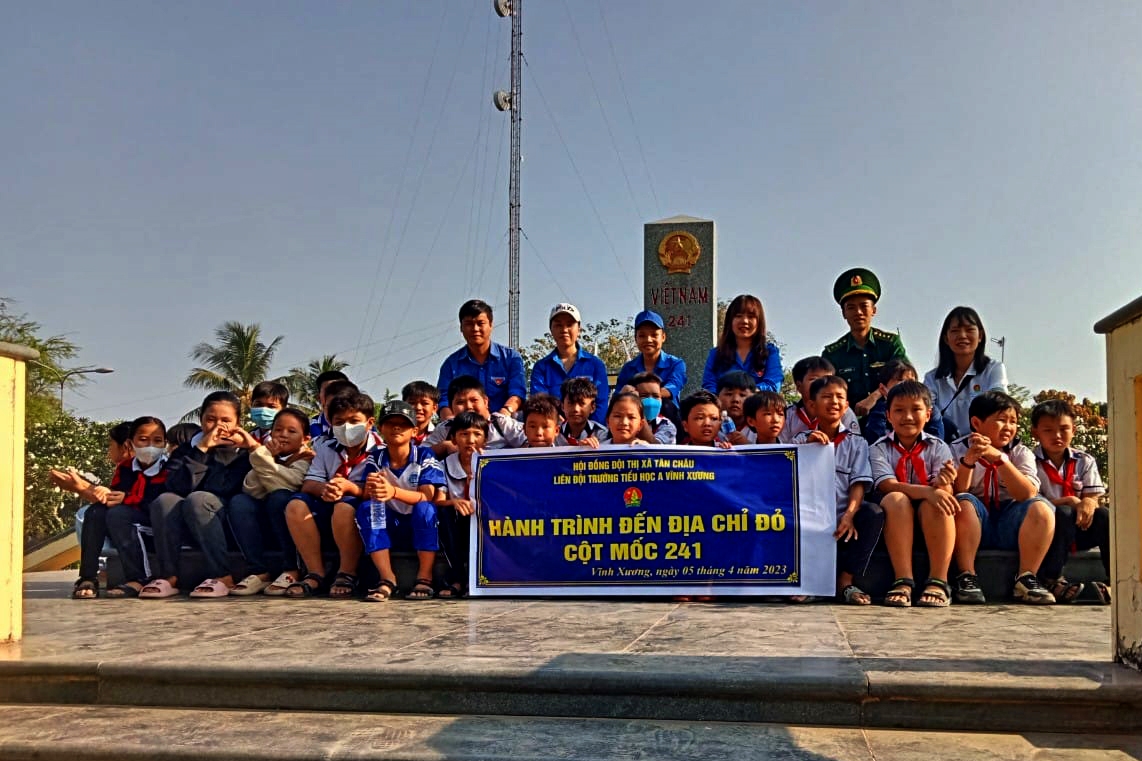 Các em học sinh chụp hình lưu niệm tại Mốc Quốc giới 241, xã Vĩnh Xương, thị xã Tân Châu, tỉnh An Giang