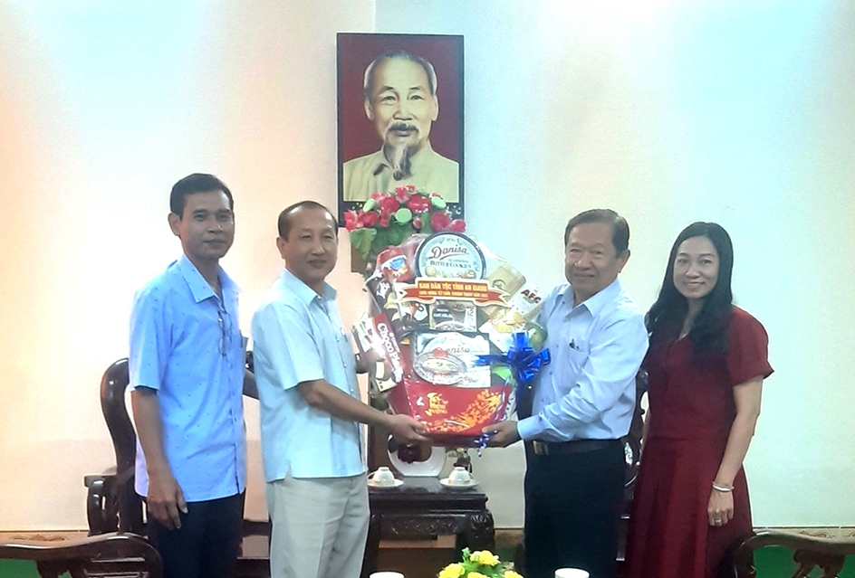 Ông Men Pholy - Trưởng Ban Dân tộc tỉnh An Giang (bên phải) tặng quà lãnh đạo Vụ công tác dân tộc địa phương 