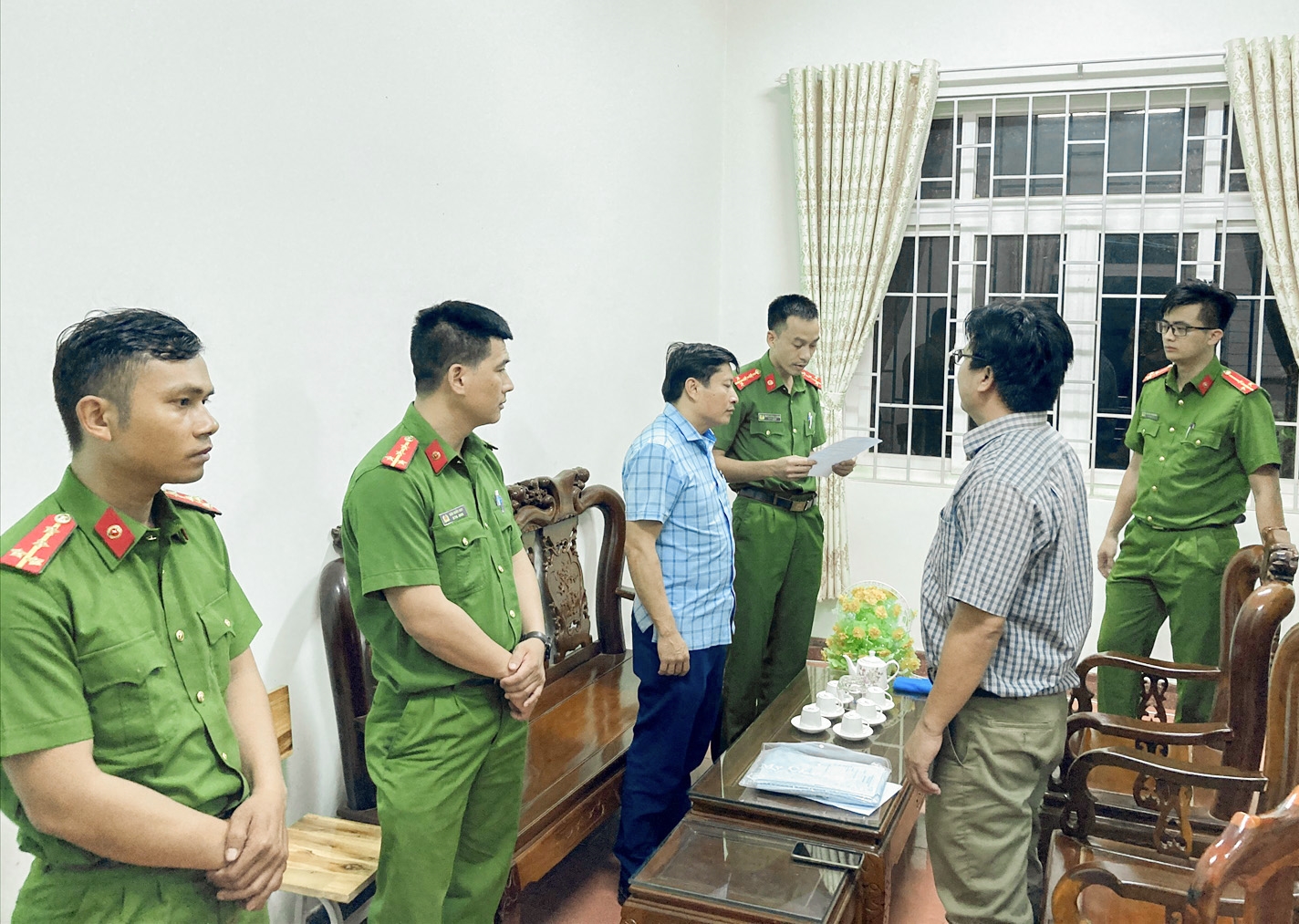 Cơ quan CSĐT Công an tỉnh Đắk Nông tống đạt các quyết định tố tụng đối với bị can Nguyễn Phi Hùng (Mặc áo kẻ màu xanh bên trái)
