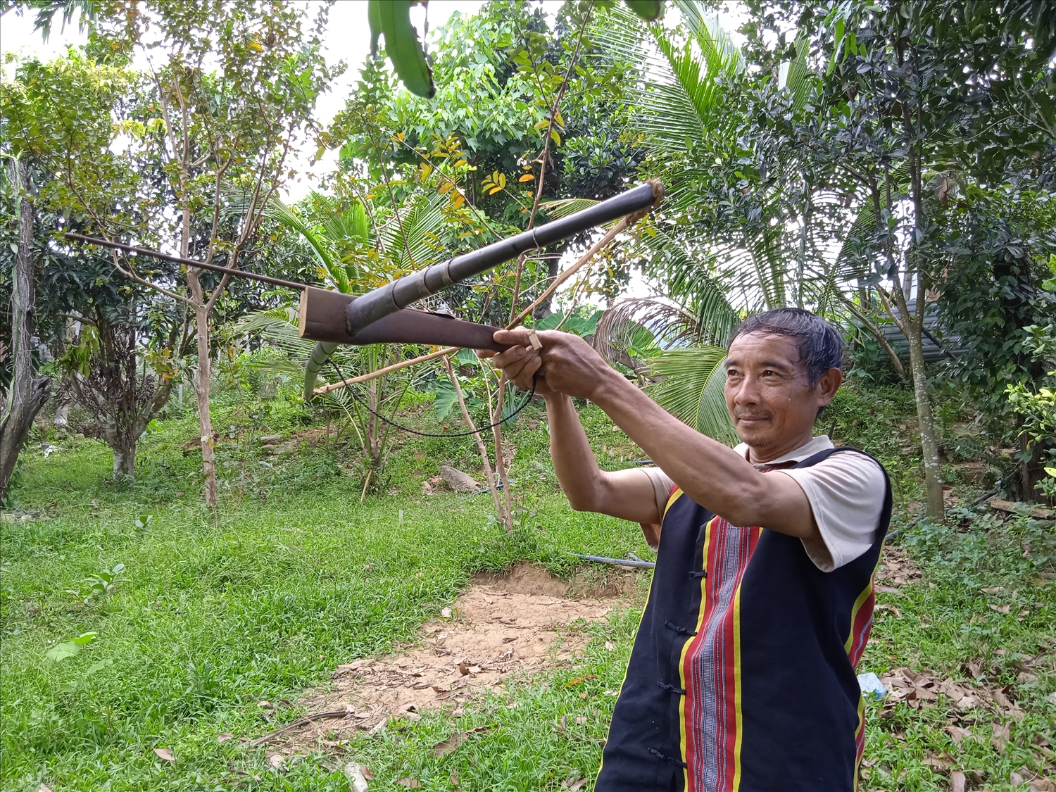 Ông Trần Văn Kiên ở tại thôn 1, xã Phước Công, huyện Phước Sơn (Quảng Nam) mô phỏng cách bắn ná truyền thống của dân tộc mình.