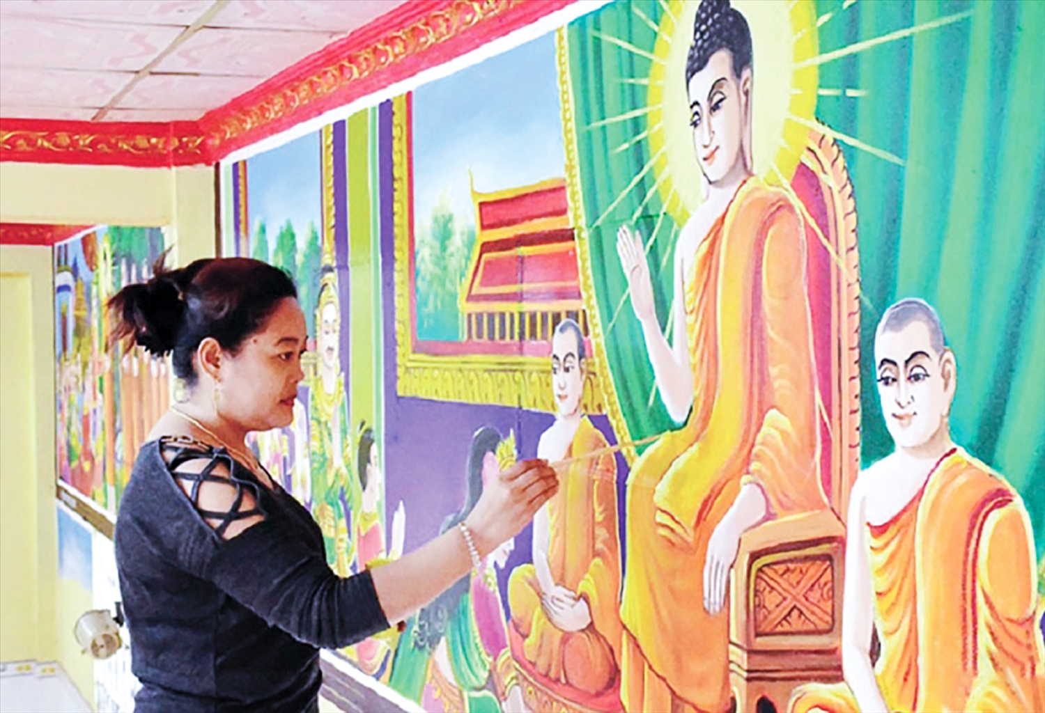 Nghệ nhân Sơn Trà The thực hiện bức tranh tường về cuộc đời Đức Phật trong một ngôi chùa ở Sóc Trăng