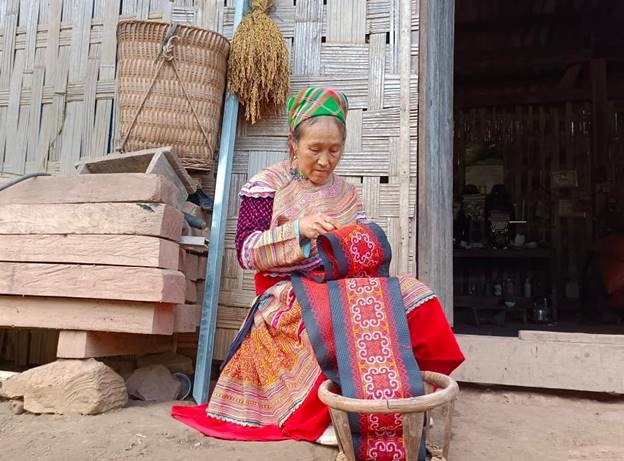 Bà Vàng Thị Dính đang thêu trang phục dân tộc Mông (nhóm Mông Hoa)