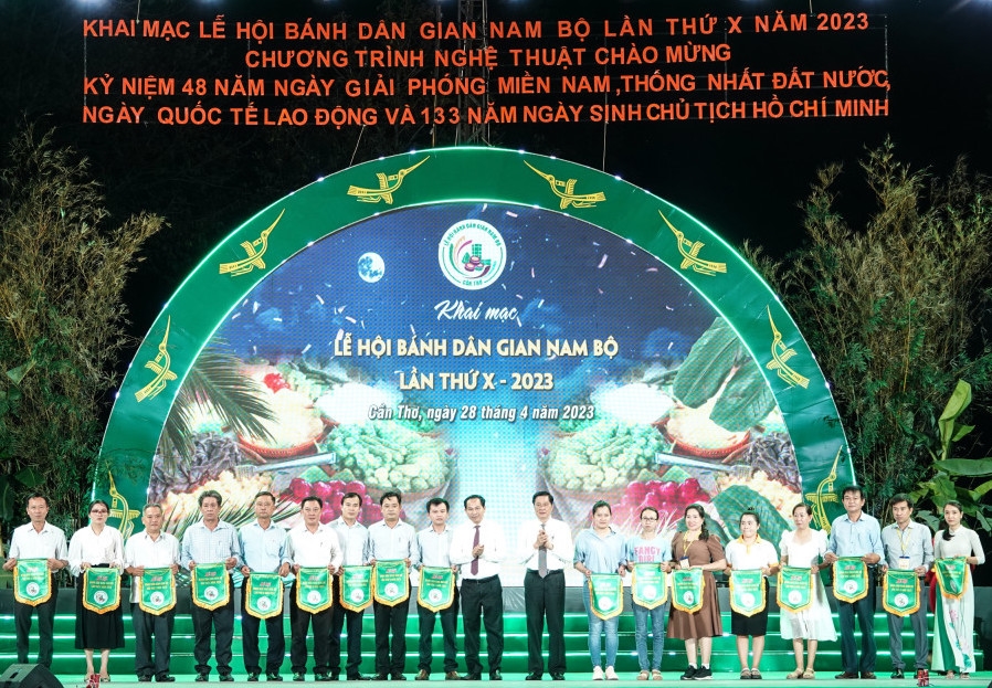 Ông Lê Quang Mạnh, Bí thư Thành ủy Cần Thơ ( đứng giữa bên trái) và ông Phạm Văn Hiểu, Phó Bí thư Thường trực Thành ủy, Chủ tịch HĐND TP Cần Thơ ( đứng giữa bên phải), trao cờ lưu niệm cho các đơn vị tham gia Lễ hội