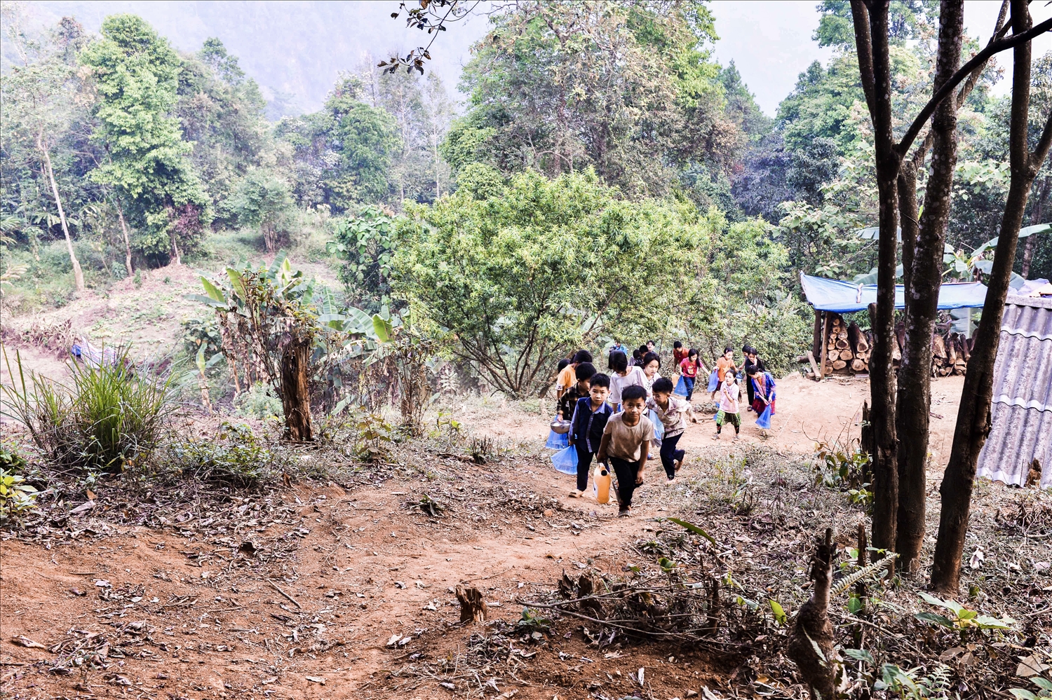 Con đường “tìm nước” mỗi ngày của các em học sinh Trường Phổ thông Dân tộc bán trú Tiểu học Phìn Hồ là ở vực cánh rừng đầu nguồn, đường đi cheo lao, dốc thẳng đứng, nên vật dụng của thầy cô mang lấy nước là can nhỏ và túi ni nong