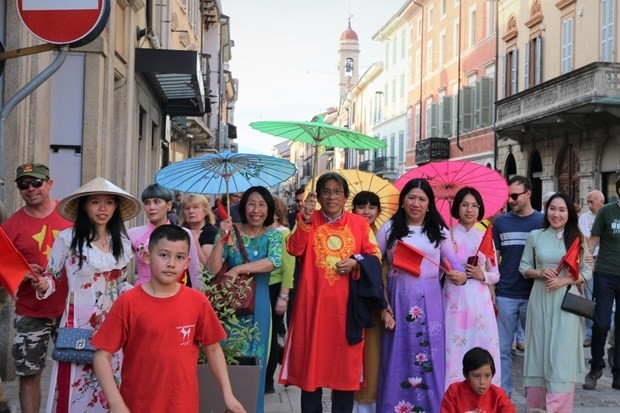 Nhóm đại diện cộng đồng người Việt tham gia diễu hành đến trung tâm Borgomanero. (Nguồn: TTXVN)